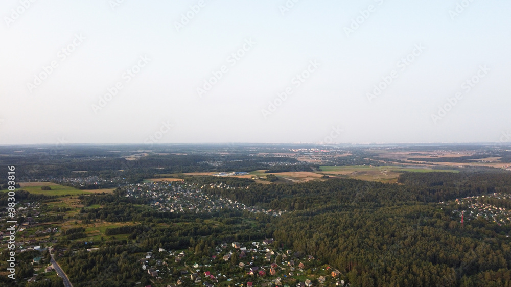 Beautiful top view of the forest and suburb with houses and a park