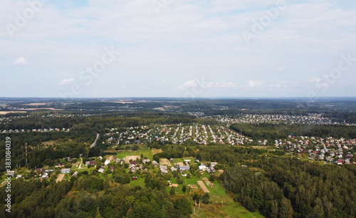 Beautiful top view of the forest and suburb with houses and a park © Payllik