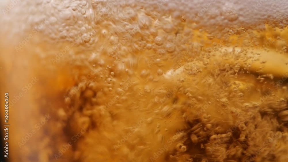 Closeup foamy fresh beer splashing and bubbling while filling glass cup in bar Closeup foamy fresh beer splashing and bubbling while filling glass cup in bar