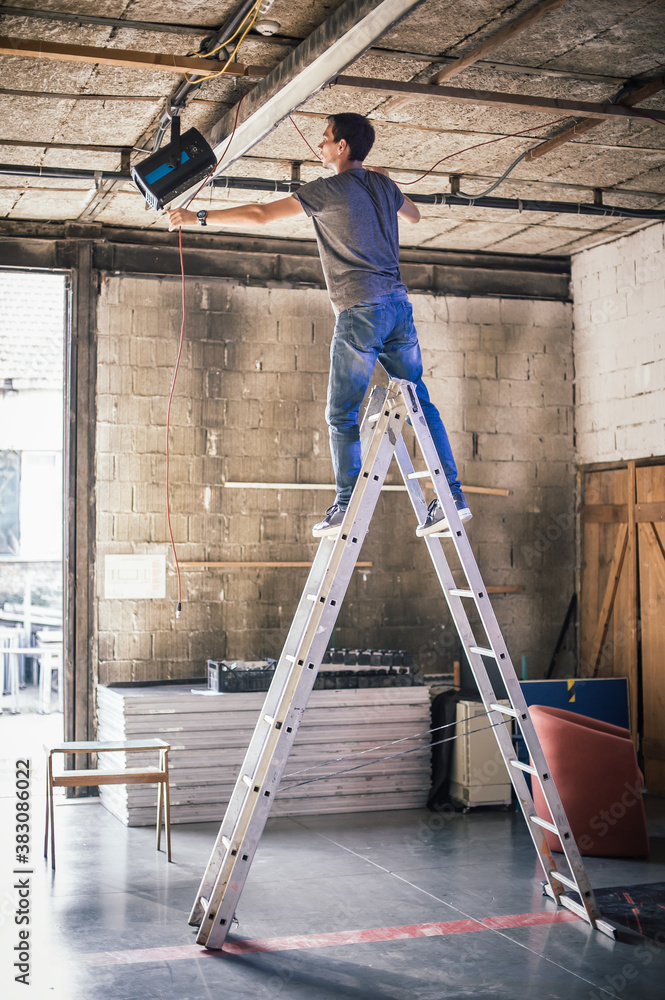 Behind the scene Lighting technician electric engineer adjusting stage lights. Spotlights in the theater Behind the scene Lighting technician electric engineer adjusting stage lights. Spotlights in the theater