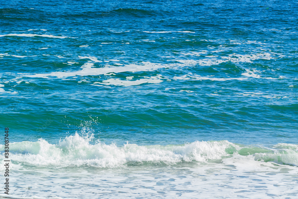 Fototapeta premium Sea with little waves and foam near the shore