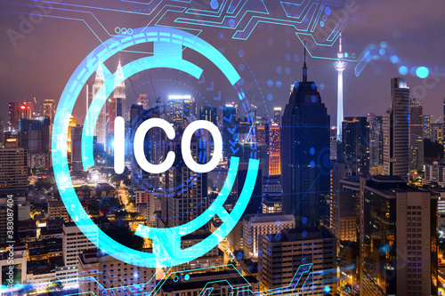 Initial coin offering hologram, night panorama city view of Kuala Lumpur. KL is the center of cryptocurrency projects in Malaysia, Asia. The concept of widespread ICO hysteria. Double exposure.