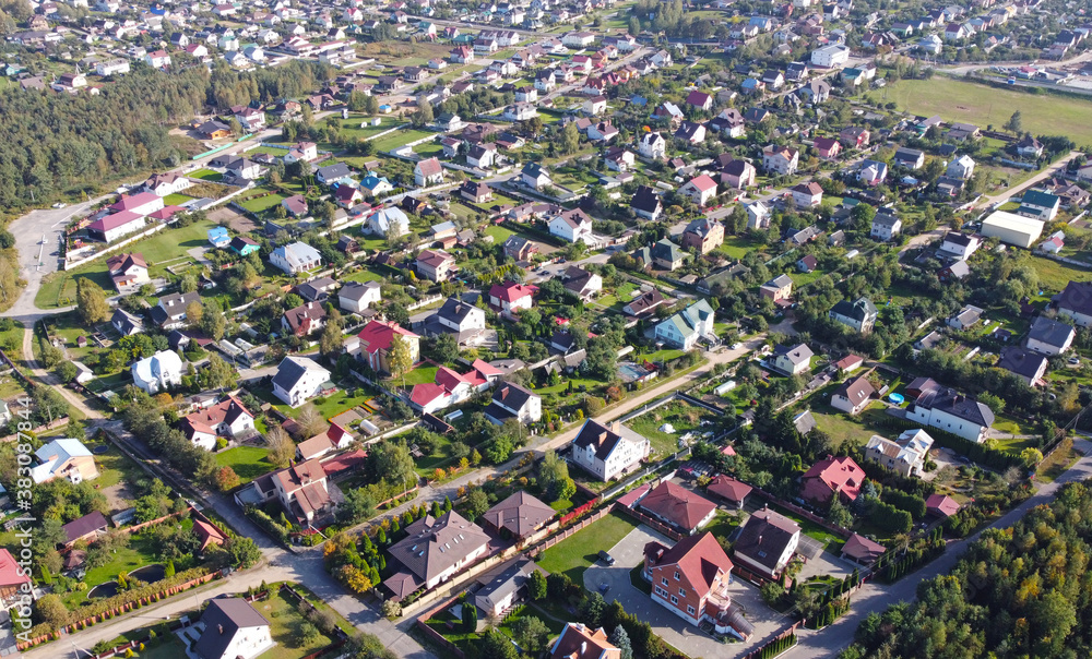 Top view of suburban villas near the park. Landscape with roofs of small houses