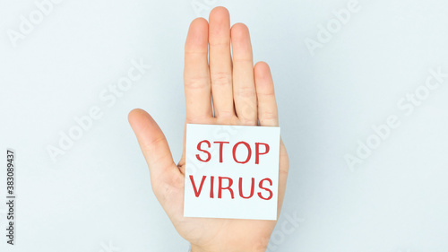 Stop virus text on card and hands holding it. Healthcare or prevention concept.