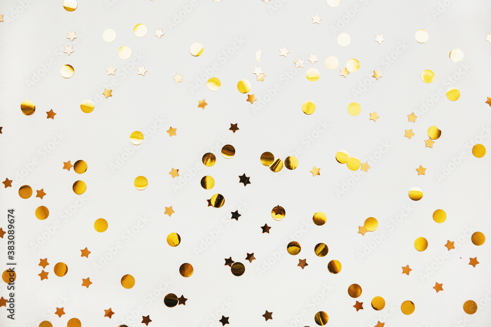 Scattered golden confetti on a white abstract festive background. Scattered golden confetti on a white abstract festive background.