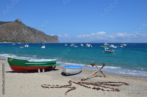 Bay of Marinello in Sicily, empty fishing boats on the mediterranean sea and on the beach, view to the Sanctuary of the Madonna on the rock