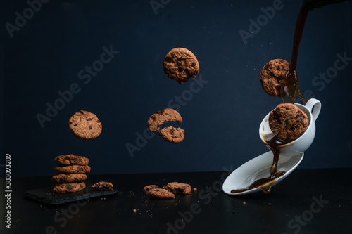 Horizontal image of flying cookies falling on a cup of coffee