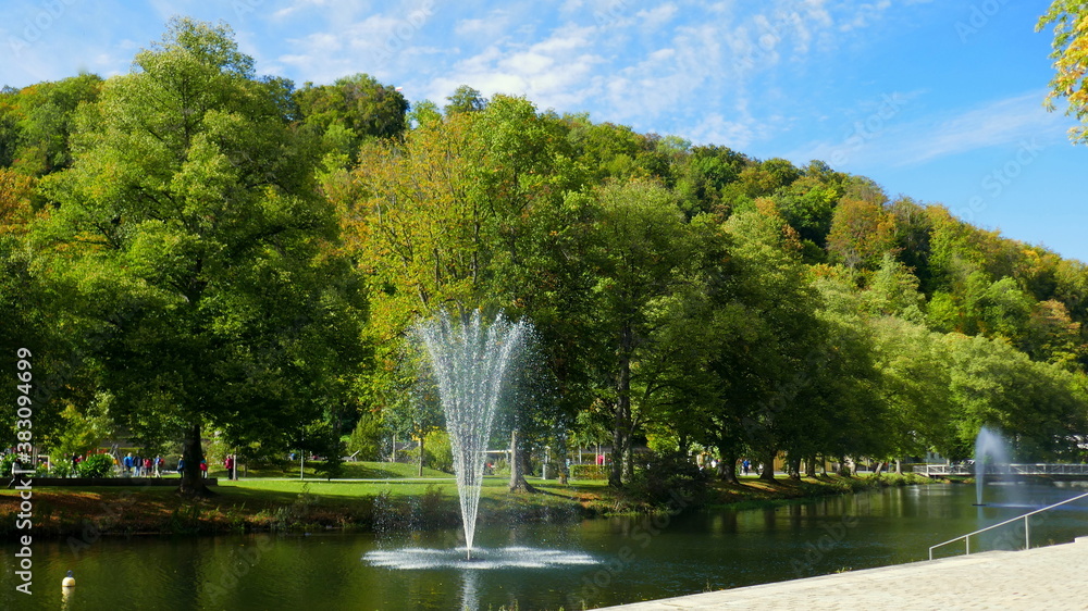Naklejka premium schöner Park am Fluss Nagold mit hohem Springbrunnen vor grünen Bäumen