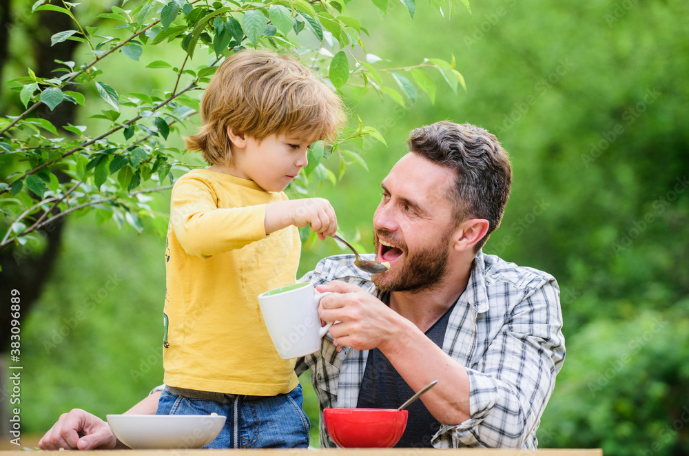 Obraz premium this is for you. healthy food and dieting. Childrens day. happy fathers day. Little boy with dad eat cereal. family dinner time. father and son eating outdoor. summer picnic. Morning breakfast