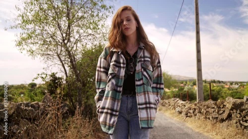 Travelling of a beautiful woman walking in the middle of a path and looking the camera