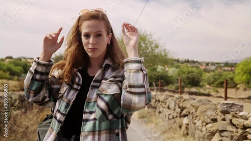 Travelling of a young woman turning to the camera and plays with it