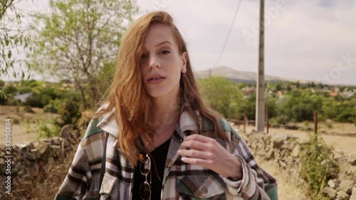 Travelling of a pretty girl turning to the camera while waves her red hair