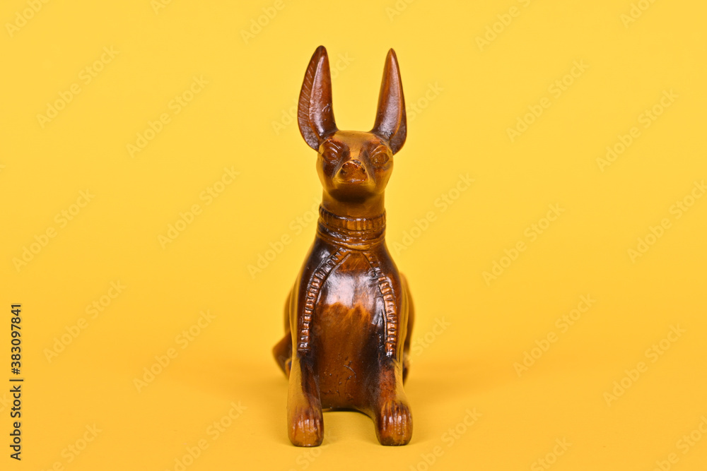 The ancient God of Egypt Anubis, a statue of a dog on a yellow