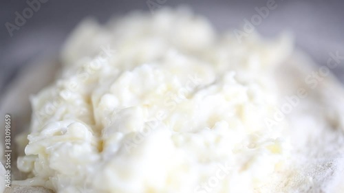 Baker prepares a pie with a cottage cheese. He puts fillings on a dough 