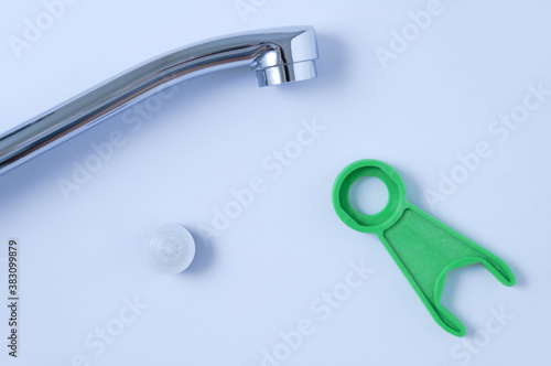 Spare faucet aerator and plumbing wrench tool.