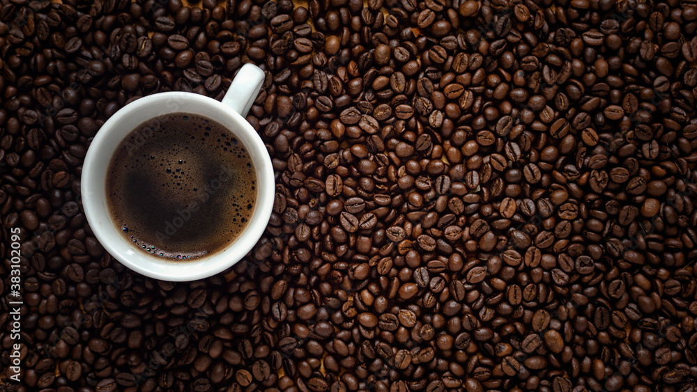 Flat lay of coffee cup on dark roasted arabica coffee beans background copy space Flat lay of coffee cup on dark roasted arabica coffee beans background copy space