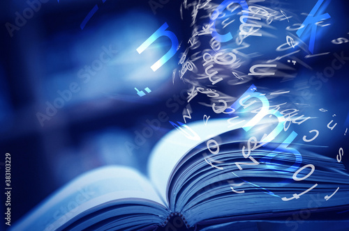 Open book on the table and english alphabet floating above the book in the library and blurred bookshelf background. education background. back to school concept.