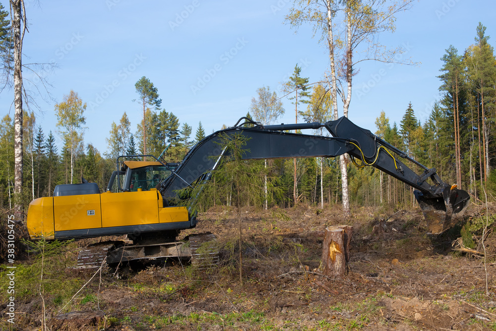 A heavy excavator works in the forest. Outstretched boom excavator. Works on drainage of the forest area. Photo of a real workflow. A heavy excavator works in the forest. Outstretched boom excavator. Works on drainage of the forest area. Photo of a real workflow.