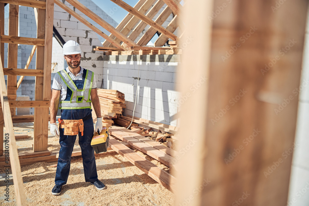 Positive delighted young builder being on construction site