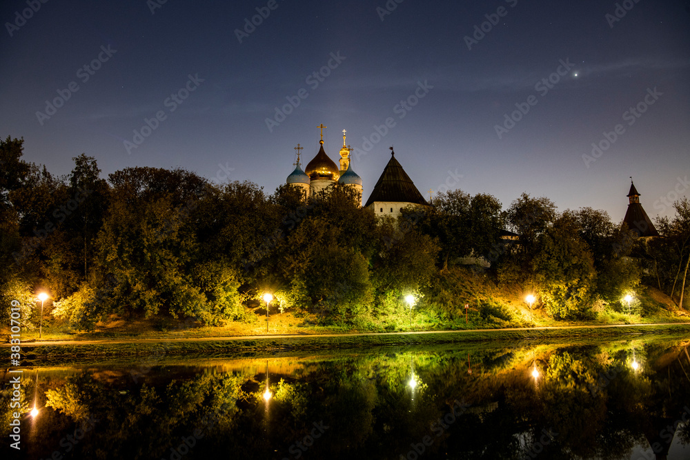 Fototapeta premium ancient monastery by the lake at sunrise against the background of burning lanterns