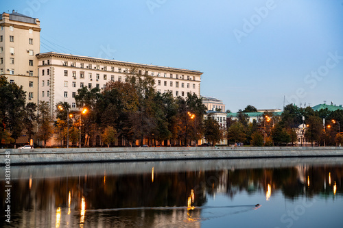 river embankment of a large metropolis at dawn with glowing lanterns reflections in the river
