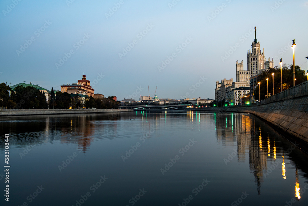 river embankment of a large metropolis at dawn with reflections in the river