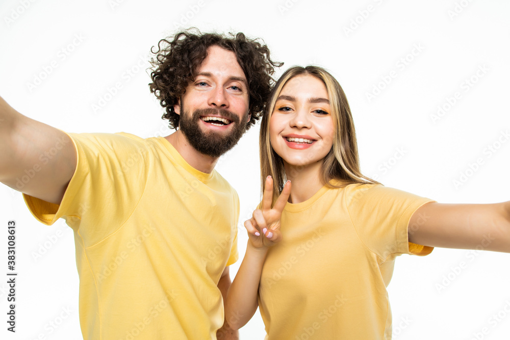 Funny couple showing tongues and gesturing v-sign while making selfie isolated on white background Funny couple showing tongues and gesturing v-sign while making selfie isolated on white background