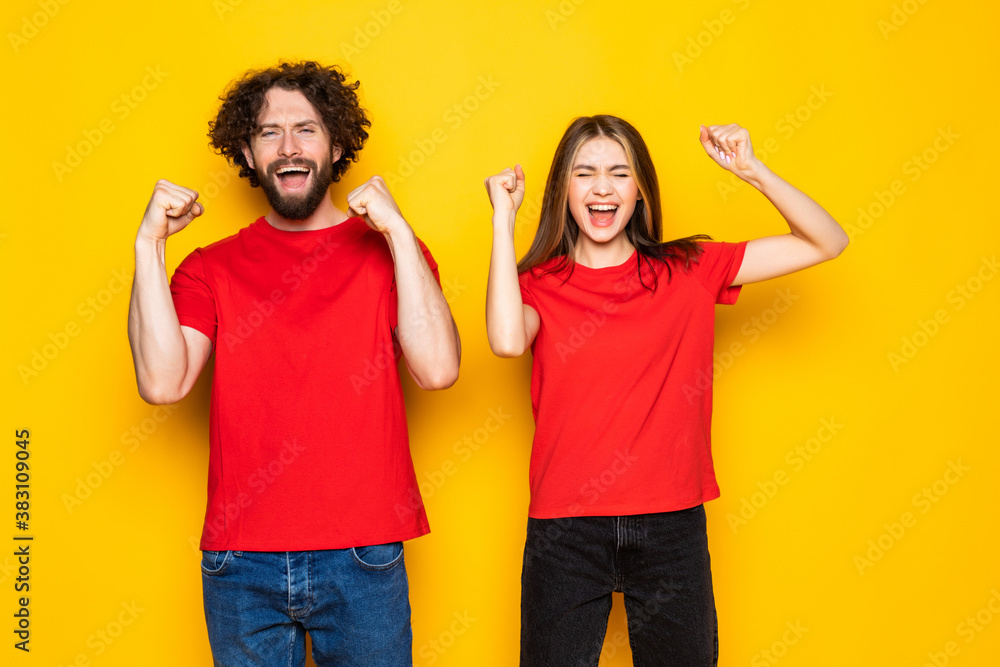 Portrait of two nice attractive couple having fun lottery win winner best luck lucky isolated over yellow background Portrait of two nice attractive couple having fun lottery win winner best luck lucky isolated over yellow background