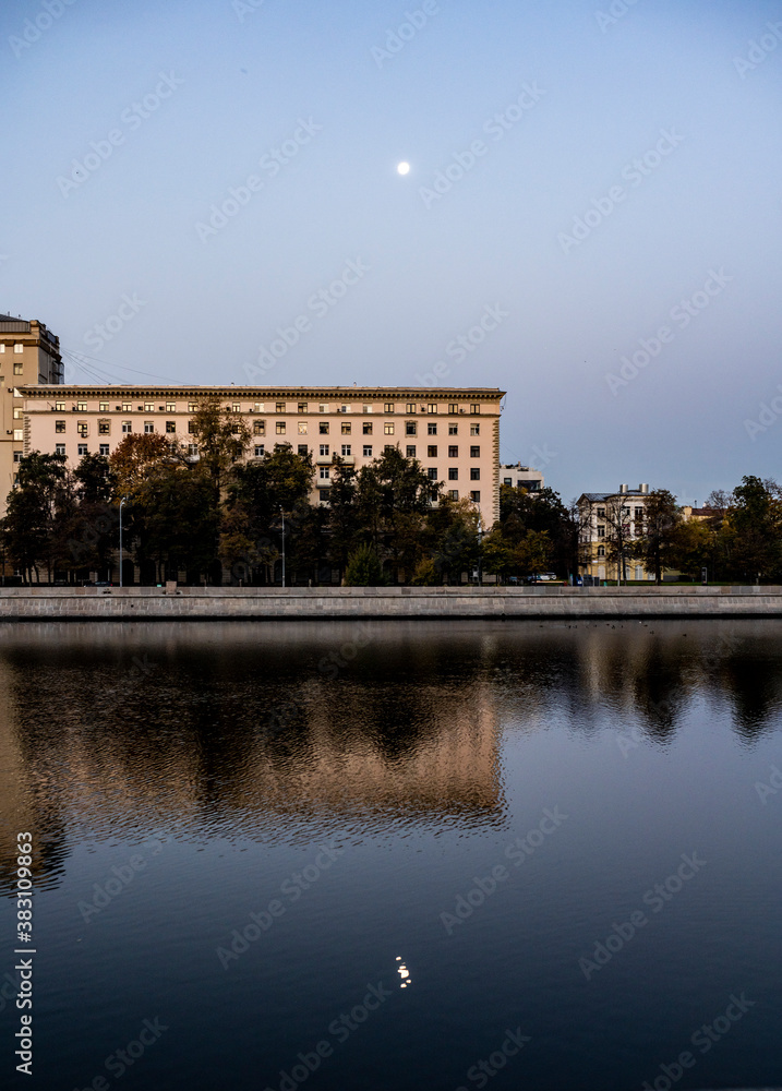 river embankment of a large metropolis at dawn with reflections in the river