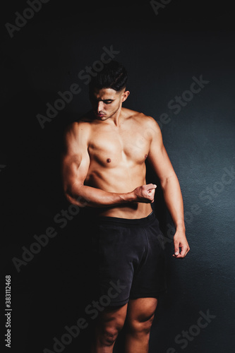 shirtless muscular man on a black background © Harry Rendón