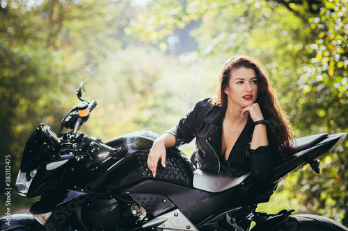 Biker sexy woman sitting on motorcycle. Outdoor lifestyle portrait © Liubomir