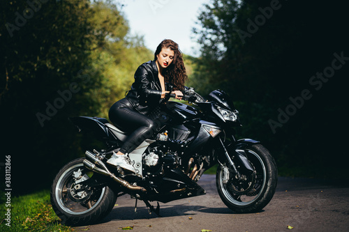 Biker sexy woman sitting on motorcycle. Outdoor lifestyle portrait