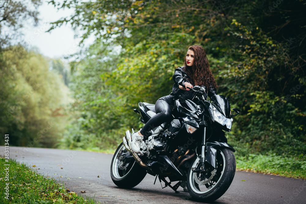 Obraz premium Biker sexy woman sitting on motorcycle. Outdoor lifestyle portrait
