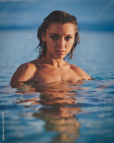 Pretty woman in the warm sea water at sunset