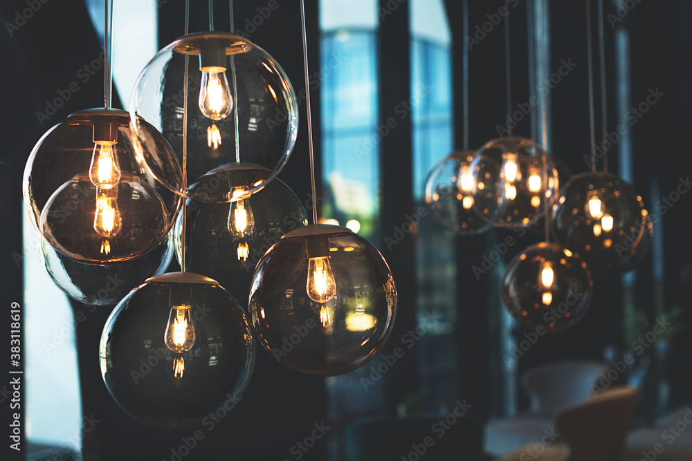 Beautiful and cosy luxury light lamp. Cosy cafe, coffee shop or lounge interior. Vintage minimal decor. Retro vibes. Many different vintage light bulbs hanging from ceiling, coffee shop interior Stock Photo