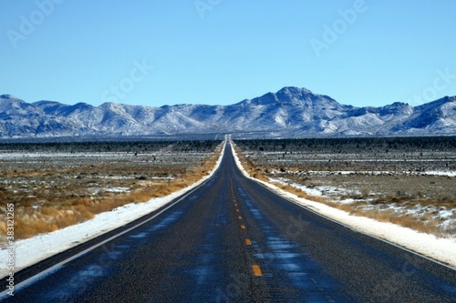 Lonely Route 93  Great basin Highway heading into the snow-capped mountain in Lincoln County Nevada.