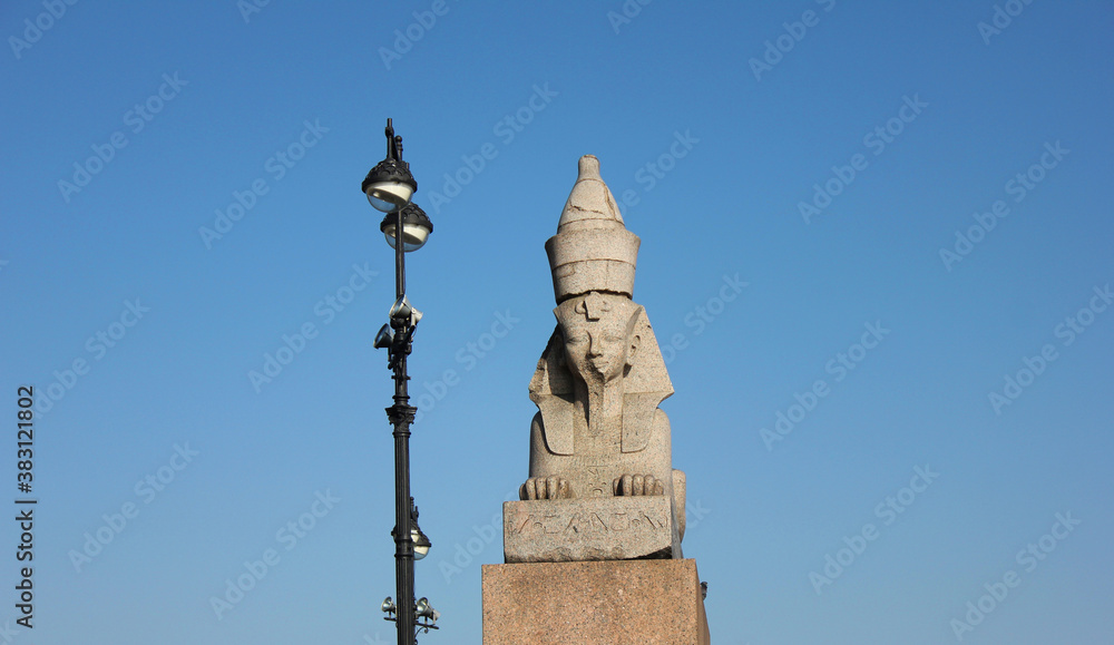 Old egyptian Sphinx on quay with Sphinxes in Saint Petersburg, Russia. Historic city landmark, ancient sphinx statue isolated on empty blue sky background. St Petersburg scenic attraction view
