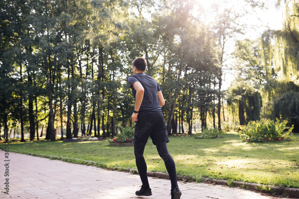 Fototapeta premium Sportsman Jog Cardio Workout. Runner Fitness Hard Training Before Running Marathon Competition. Running Man Fitness Exercising. Athlete Jogging In Park Preparing Triathlon. Sport Healthy Lifestyle