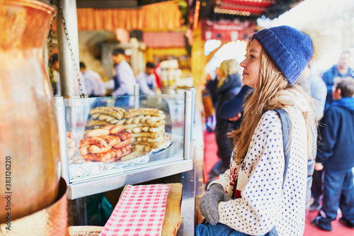 Beautiful young woman buying sausages on traditional Christmas market