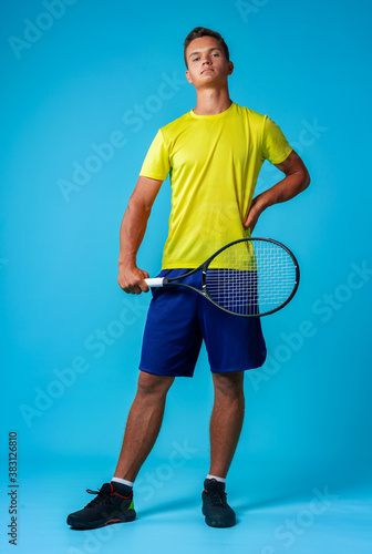 Full length studio portrait of a tennis player man on blue background © fotofabrika