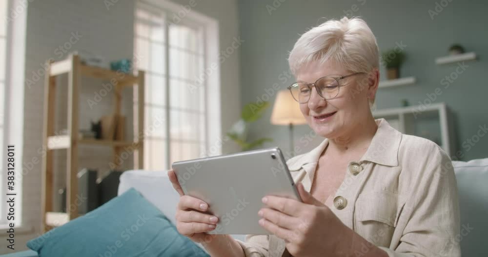 Senior caucasian lady having video chat with relatives or consulting with doctor during self-isolation, using tablet computer at home 4k footage Senior caucasian lady having video chat with relatives or consulting with doctor during self-isolation, using tablet computer at home 4k footage