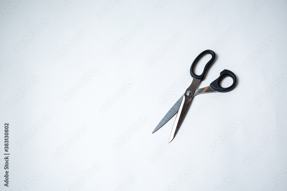 Black scissors for a tailor lie on a white background. Close-up. View from above Black scissors for a tailor lie on a white background. Close-up. View from above