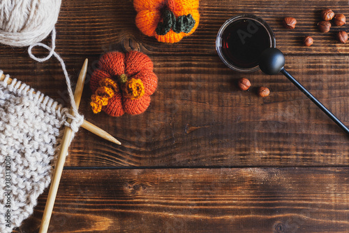 Autumn wood background with black tea and knitted accessories, top view