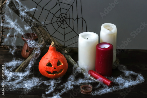 Funny Halloween pumpkin head with candles, cobwebs, bats. Halloween decor with cute pumpkin and extinguished candles photo