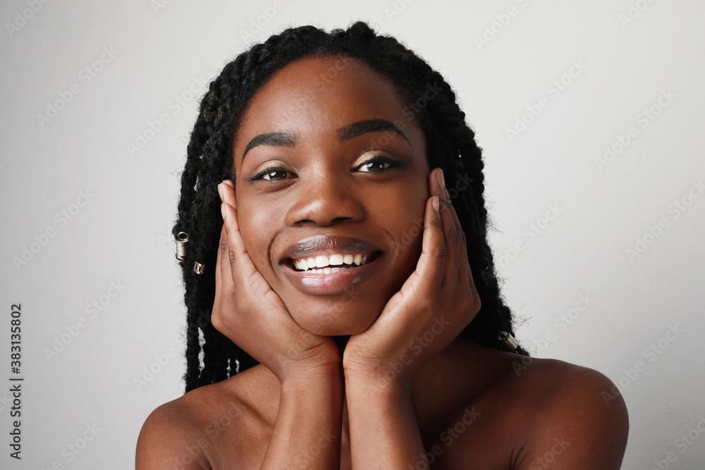Close-up of young black attractive woman with beautiful smile, posing over white background. Skin care concept. Close-up of young black attractive woman with beautiful smile, posing over white background. Skin care concept.