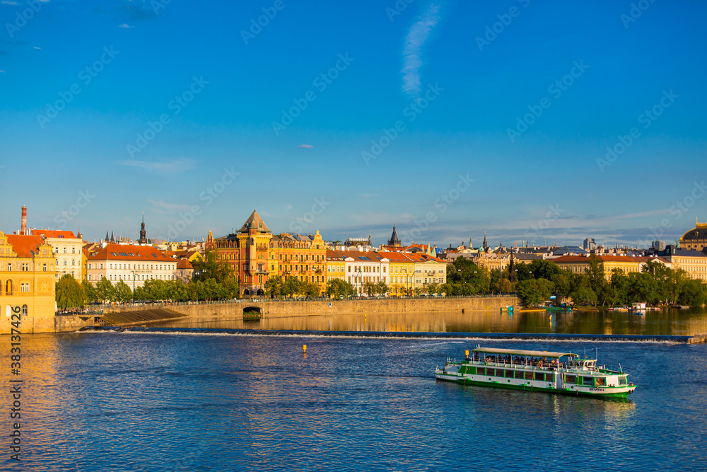 Fototapeta premium Summer landscape of Prague view of the Ltava river on which ferries with tourists float