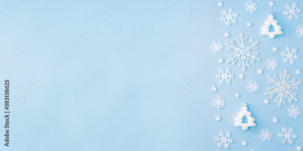 Flat lay border with snowflakes and christmas decorationon a blue background