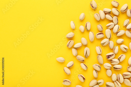 Tasty pistachios on yellow background