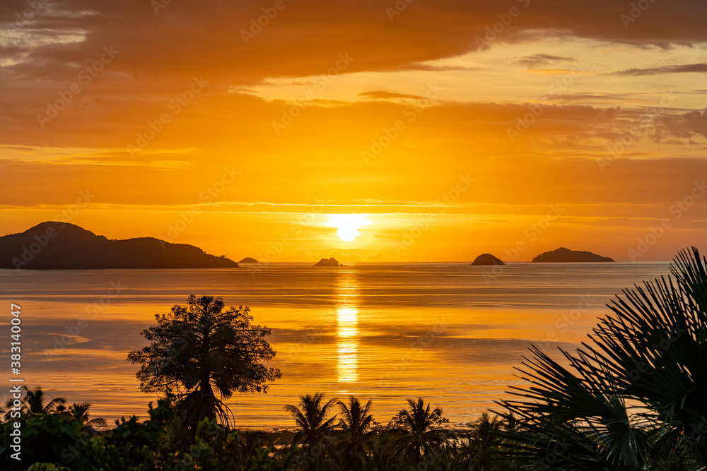 Goldener Sonnenuntergang vor Ozean und Palmen