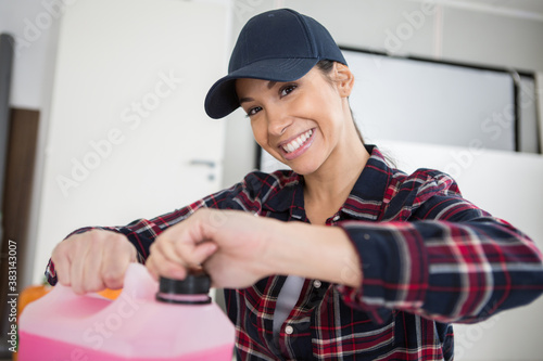 young and happy woman opening a cleaning container